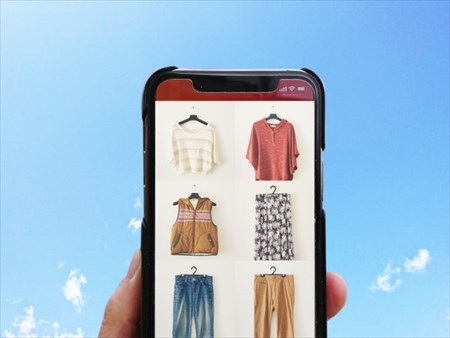 スマートフォンで古着の通販サイトを見る人